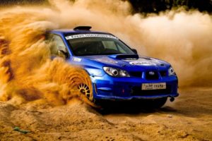 Carro Subaru Impreza em prova de rali jogando pueira para cima